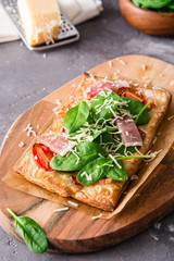 Homemade puff pastry pie with spinach, ham and cheese.