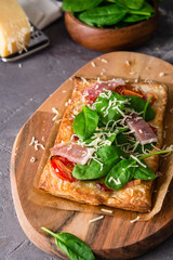 Homemade puff pastry pie with spinach, ham and cheese.