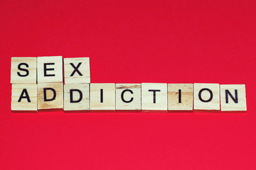 Wooden blocks on a red background spelling words Sex Addiction