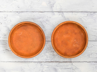 Two brown ceramic dish on white rustic wooden background