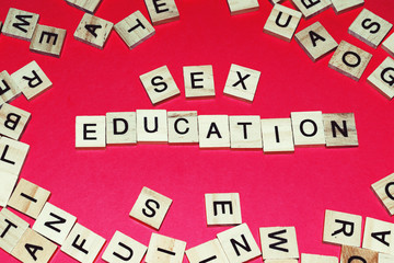Wooden blocks on a red background spelling words Sex Education