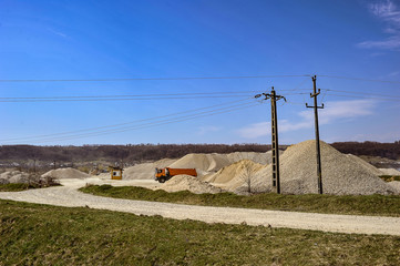 Fototapeta na wymiar Gravel excavation site in a sunny day industrial machines.