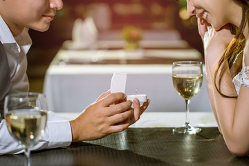 Man open a ring box to give a gift to his girlfriend.