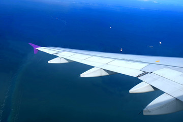 Obraz premium view from aircraft fly over the sea, aircraft Wing and ship with Blue sea