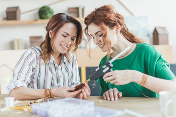 Fototapeta premium young women making accessory with glue gun
