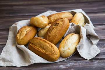 Freshly baked bread buns on a linen towel, whole bread buns heap with crust freshly oven baked