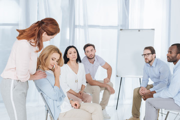 Obraz premium psychotherapist supporting middle aged woman during group therapy
