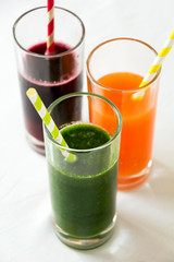 Detox drinks in glasses: fresh smoothies from vegetables: beet, carrot, spinach, cucumber and apple on white background