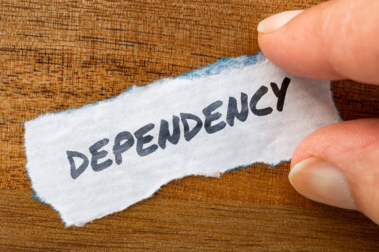 Dependency concept and theme written on old paper on a grunge background