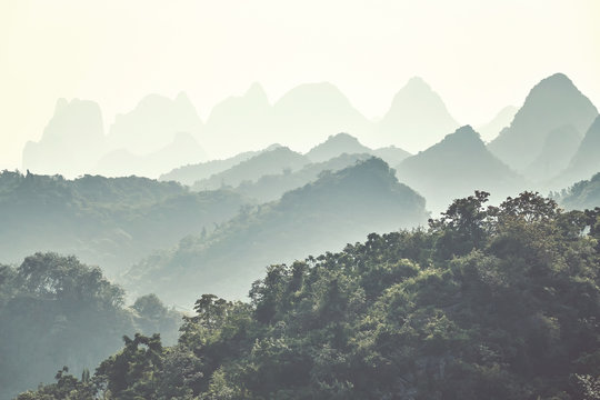 Retro toned Karst mountainous landscape around Guilin on a foggy day. It is one of China top tourist destinations. 
