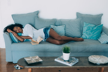 Beautiful black young woman sleeping in the sofa .