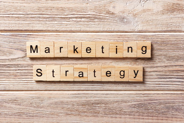 MARKETING STRATEGY word written on wood block. MARKETING STRATEGY text on table, concept