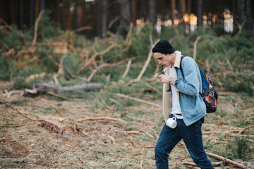 Man with mustache smoke cigarette on forest landscape. Bad habit, addiction concept. Wanderlust, vacation, traveling