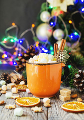 a cup of Christmas hot cocoa with marshmallow New Year's lights and decorations, selective focus
