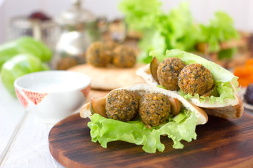 Nice vegetarian falafel in pita bread on wooden board.