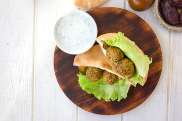 Top view of falafel with vegetables and pita bread.