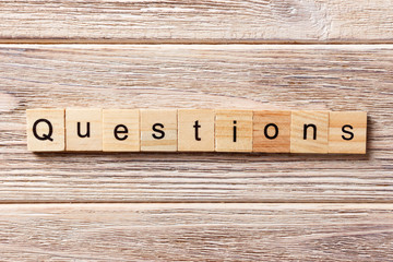 Questions word written on wood block. Questions text on table, concept