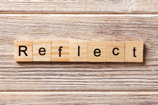 Reflect word written on wood block. Reflect text on table, concept
