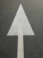 signs with white arrow on the asphalt