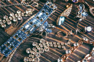 Gold jewelery with large blue gems on a wooden background © jalisko