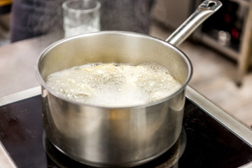 pasta in boiling water in pot on electric stove