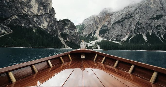 Closeup wooden boat in the middle of lake and background big mountains. 4k