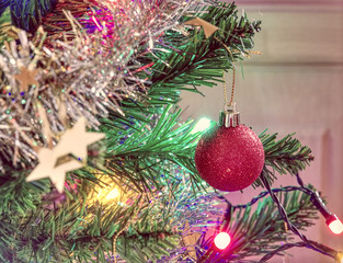 Christmas tree decorated with red balls, golden stars and lights                  