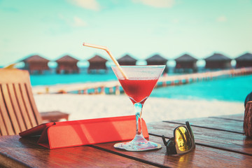 cocktail, touch pad and sun glasses on beach vacation