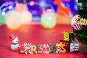 Christmas letter decoration with snowman and presents on bokeh light
