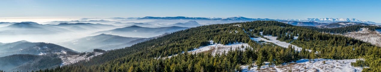 Fototapeta na wymiar Panorama of winter High Tatras and many small hills in mist - view from Skalisko