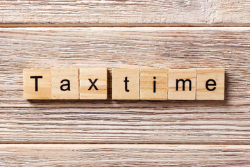 tax time word written on wood block. tax time text on table, concept