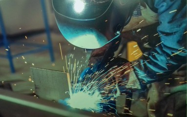 MAG welder during the development of the steel structure in a standing position
