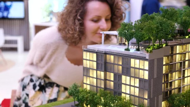 Woman Choosing New Apartment Looking At Building Miniature. Closeup. 4K. 