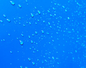 Naklejka na ściany i meble Close up view. Water droplets are stick on the blue wall surface.
