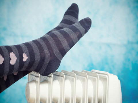 Female feet above the heater.