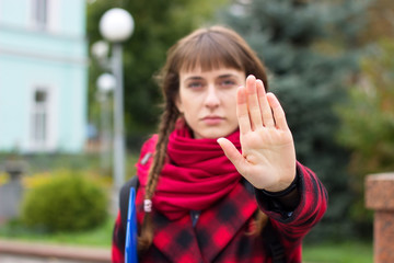Teenager shows the palm gesture of Stop at park