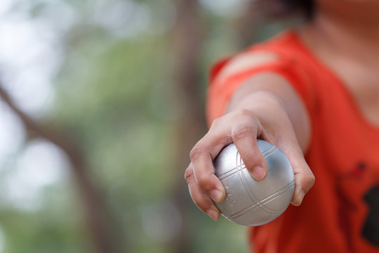 Hand of female boule holding boule or petanque ball on match
