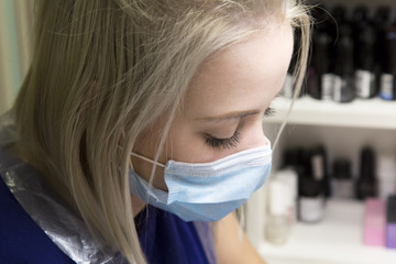 Beautiful nails on the hands of brunettes. In the beauty salon the beautiful blonde master makes a girl a manicure.