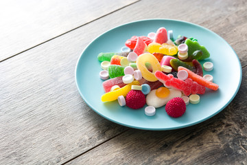 Colorful childs sweets and treats in plate on wooden table