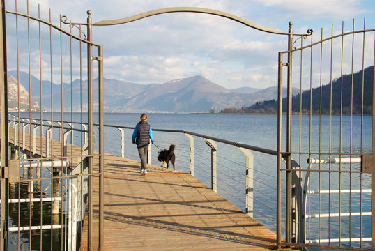 Ragazza a passeggio con il cane sul lungolago di Sarnico
