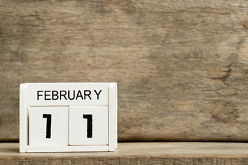 White block calendar present date 11 and month February on wood background