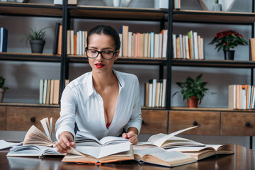 young sexy teacher sitting at library and reading