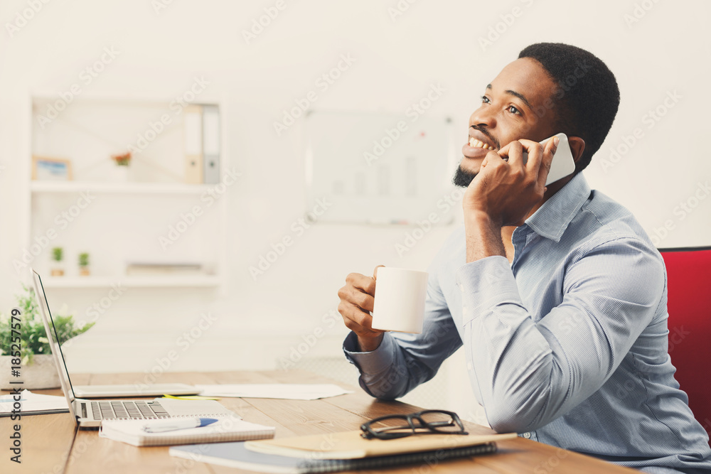 Wall mural young black businessman talking on mobile phone