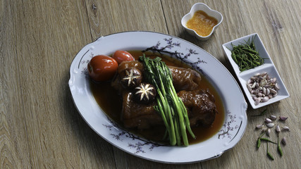 Stewed pork leg in white dish on picket background with dim lightweight Asia food / picture and Selective focus.