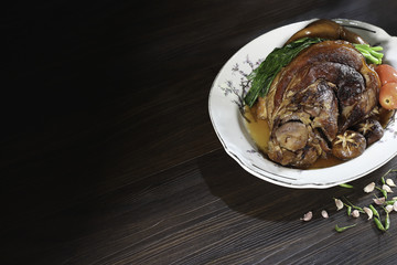 Stewed pork leg in white dish on wood background with dim lightweight Asia food / picture and Selective focus.High fat diet.