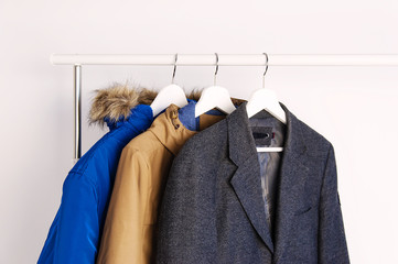 Outer clothing on the shoulders on the dressing counter. Shoes and bags on the floor. On a white background. © olgaarkhipenko