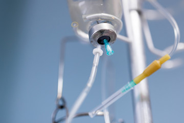 Medical saline iv drip  close up on  light blue background at hospital