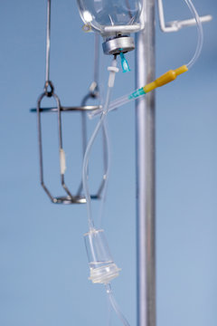 Medical saline iv drip  close up on  light blue background at hospital
