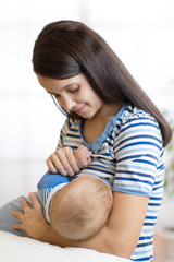 Young woman breast feeding baby.