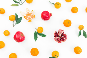 Citrus with leaves and garnet fruits on white background. Flat lay. Top view